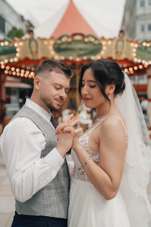 Couple de mariés amoureux devant un manège en bois, photographe de mariage.